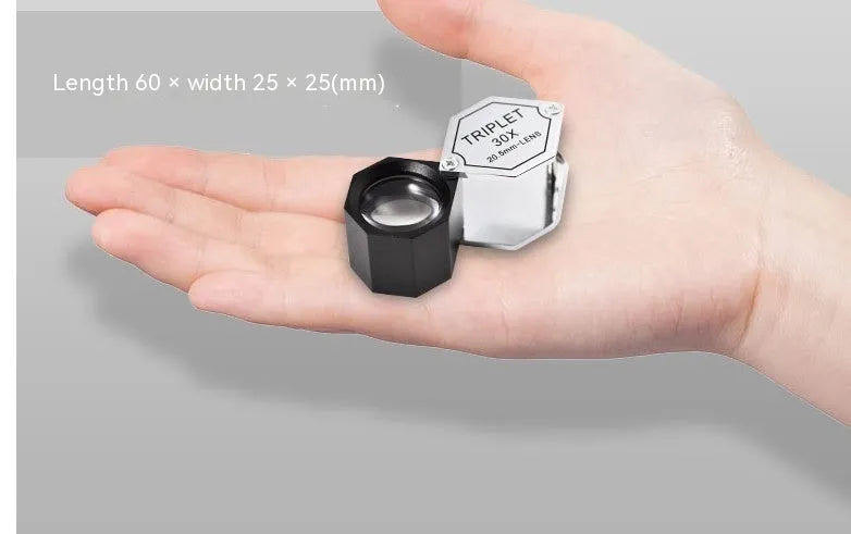 Handheld metal magnifying glass with optical glass lens for jewellery and coin identification.