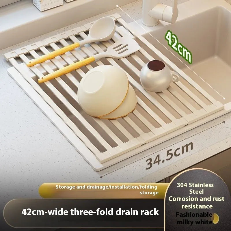 Foldable milky white stainless steel kitchen draining rack with dishes, shown next to a sink.
