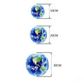 Glow in the dark 3D planet Earth wall sticker on a dark background.