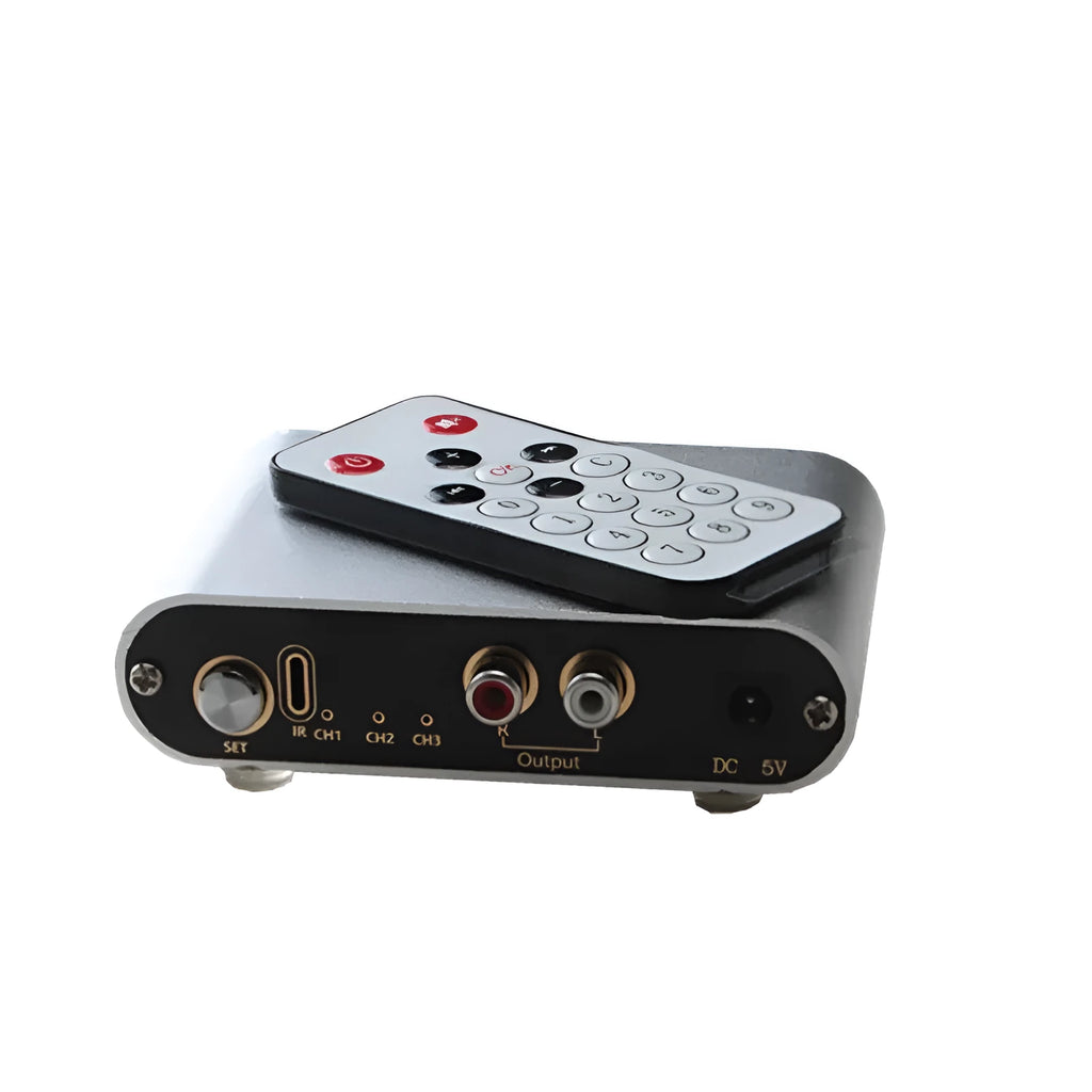Silver aluminium audio source switch unit with front-panel buttons and infrared remote control.