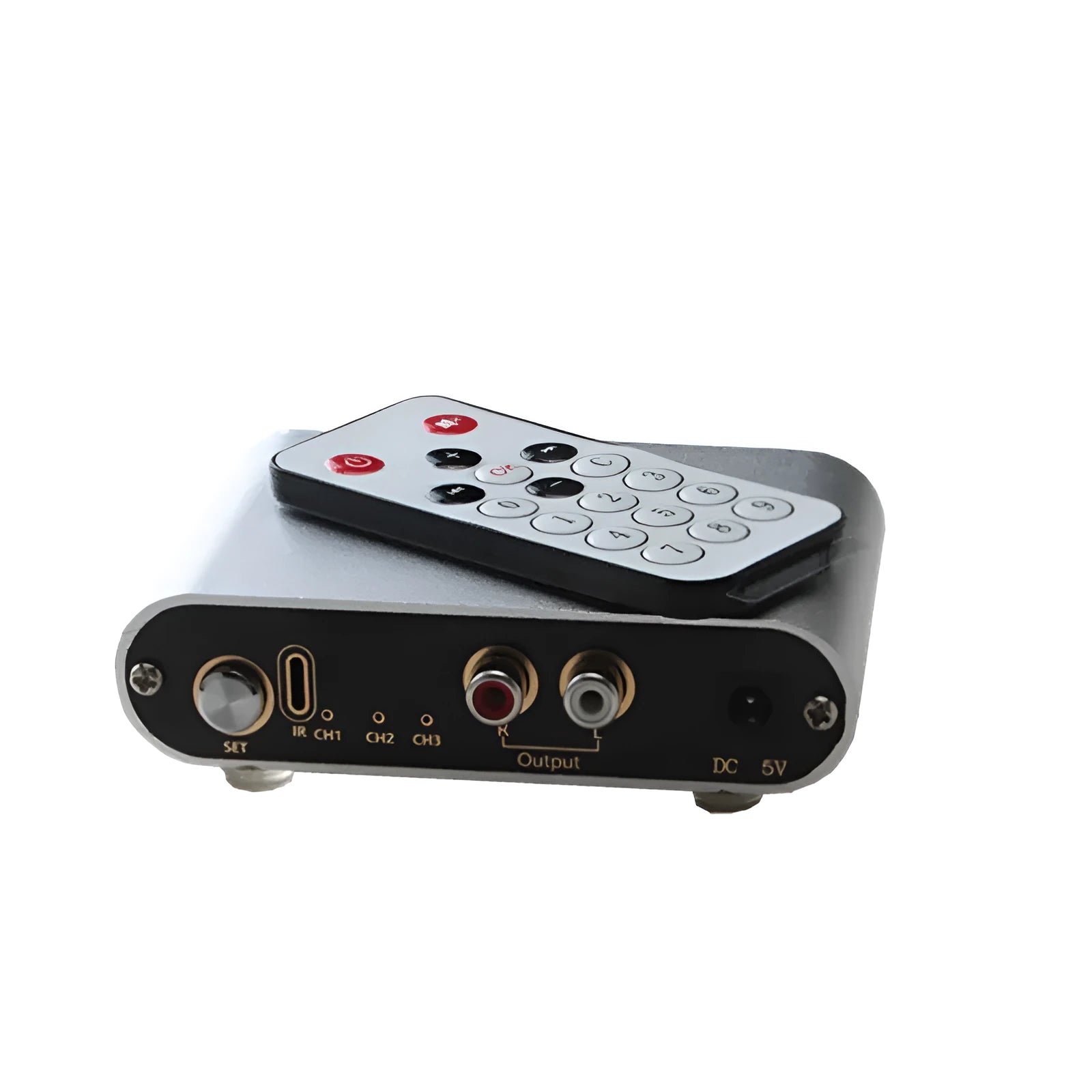 Silver aluminium audio source switch unit with front-panel buttons and infrared remote control.
