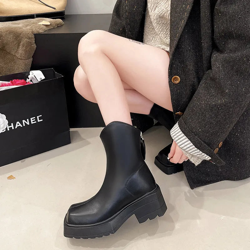 Black women's platform Martin ankle boots with a square toe and high heel on a white background