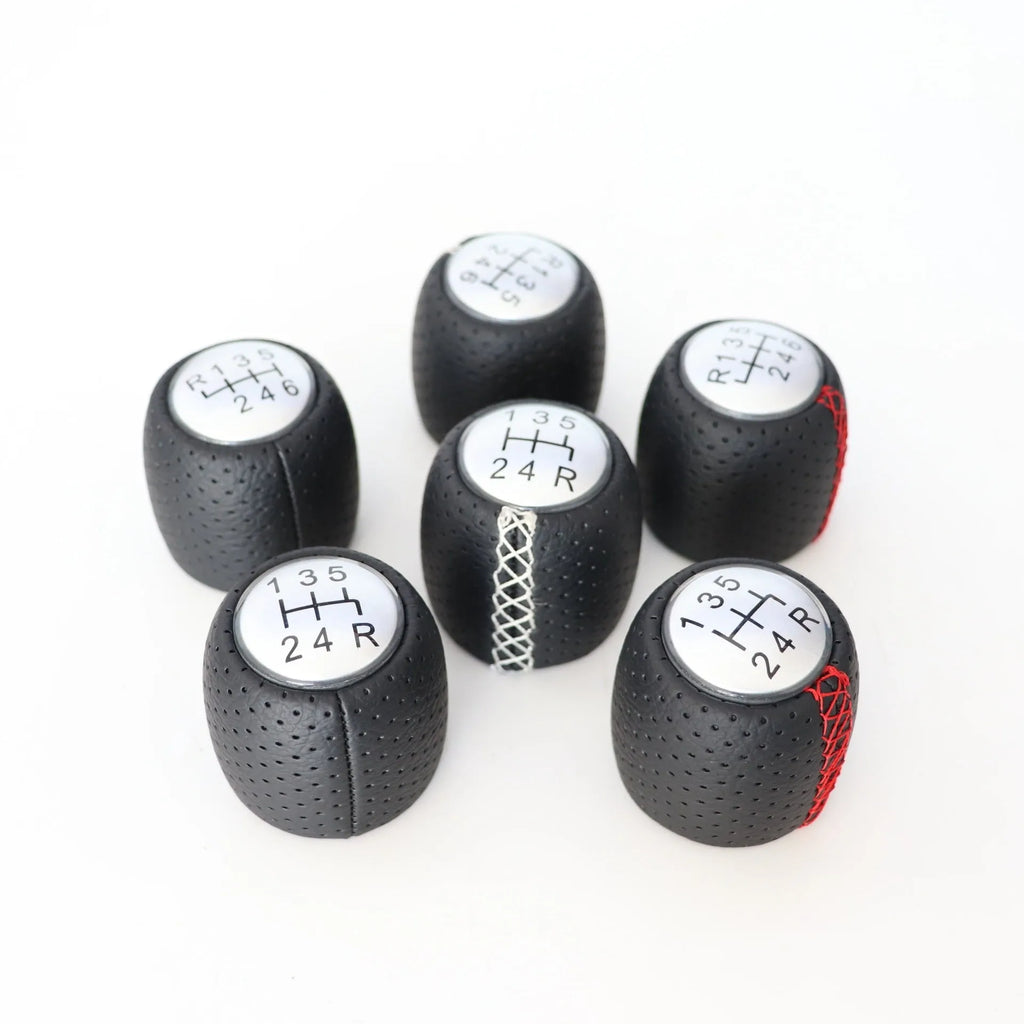 Sewn wrapped perforated leather gear lever handball for Alpha car in black, red, and white line options.