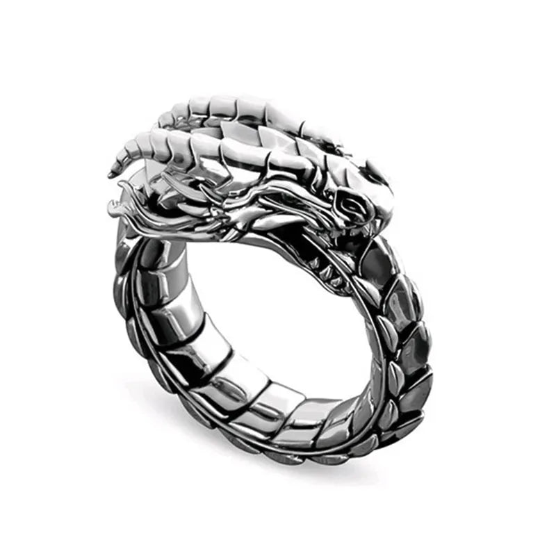Vintage dragon male ring in ancient silver metal on a plain background.