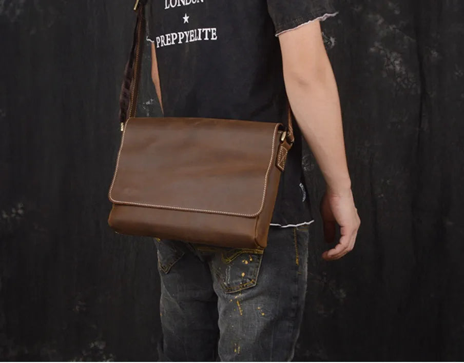 Vintage brown men's leather messenger bag showing interior compartments and adjustable shoulder strap