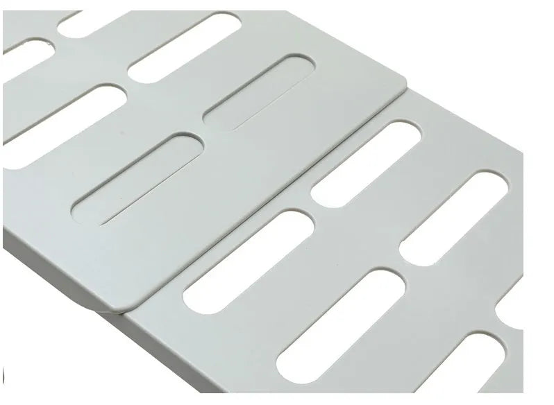 White telescopic plastic kitchen rack extended to 69cm height on kitchen countertop
