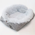 Grey plush pet blanket and bed with raised sides and a black non-slip bottom, shown on a wooden floor.