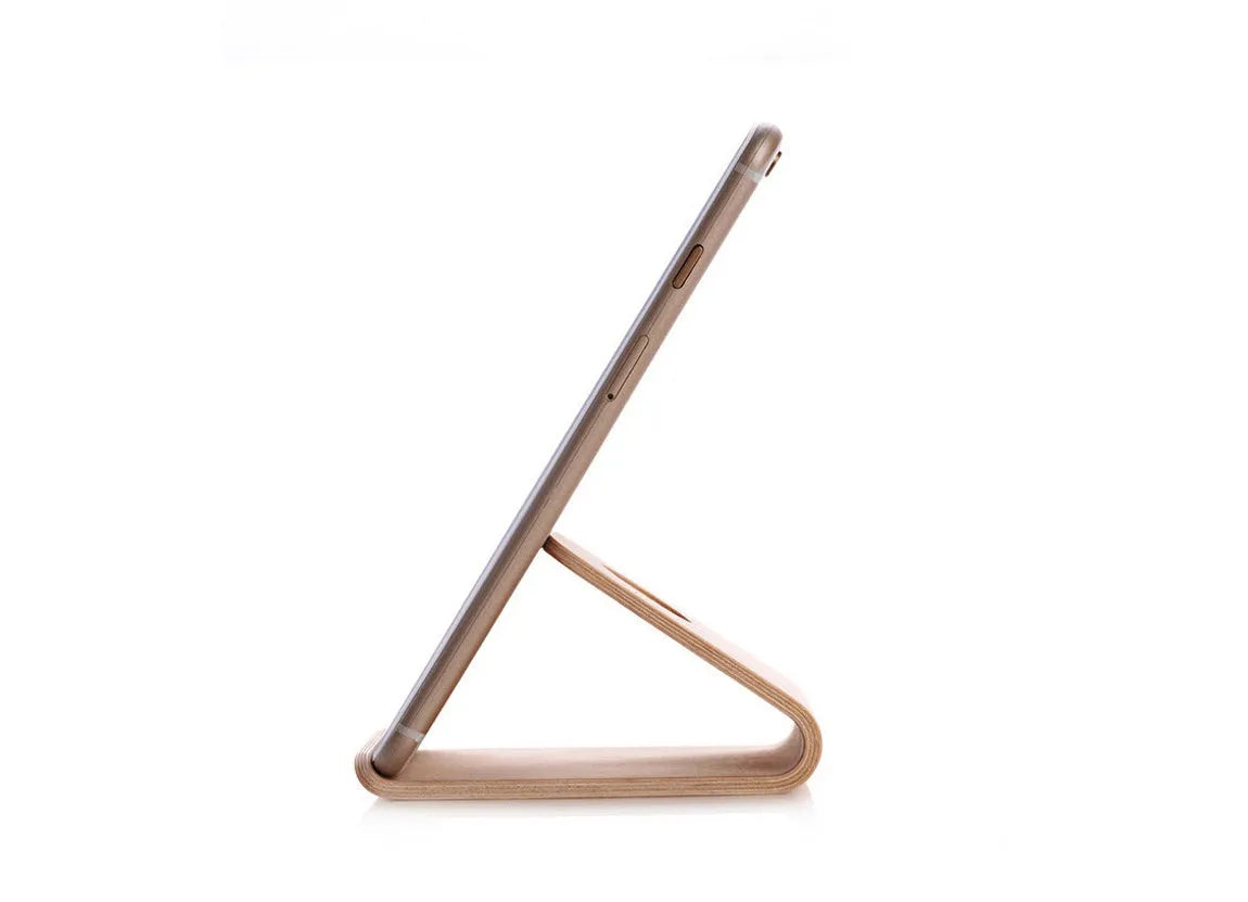 A wooden phone stand holding an iPhone in landscape mode on a desk.