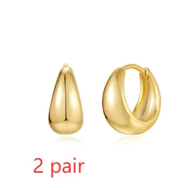 Golden brass diamond earclip earrings with simple geometric round design on white background