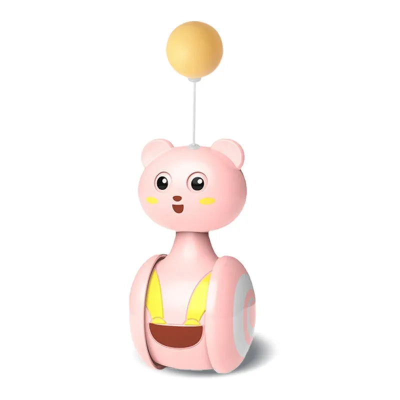 Pink and blue cat tumbler toys with feather lures and rolling balls on a wooden floor.