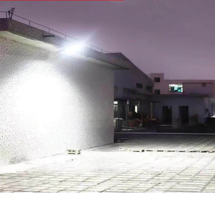 Black solar-powered outdoor security light with motion sensor mounted on a wall.
