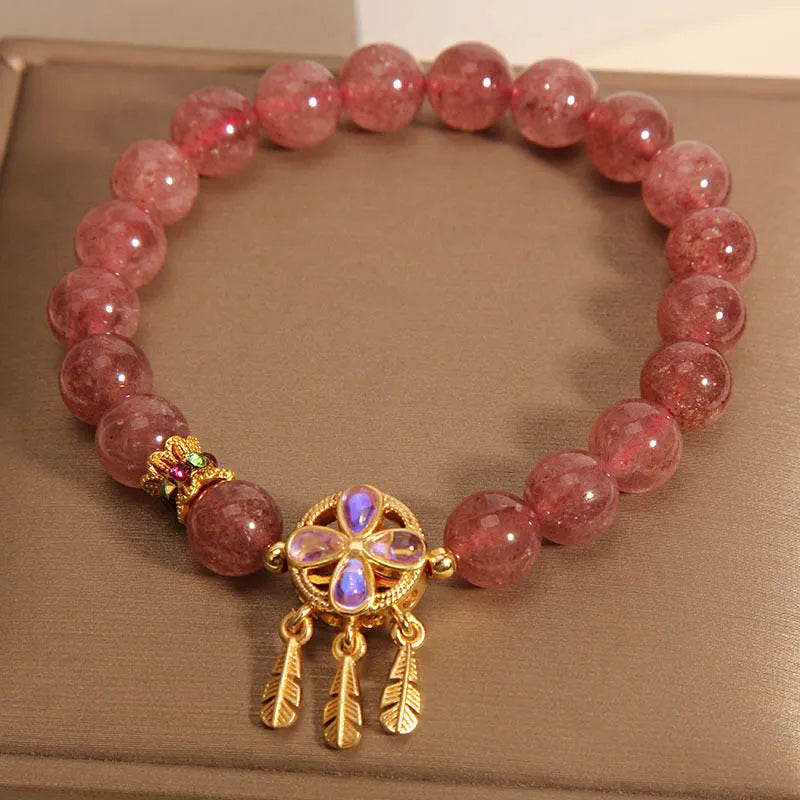 Women's strawberry quartz crystal bracelet with a four leaf dream catcher ball pendant.