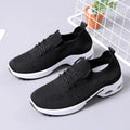 Women's black mesh casual sneakers with lace-up front and round toe on a grey background.