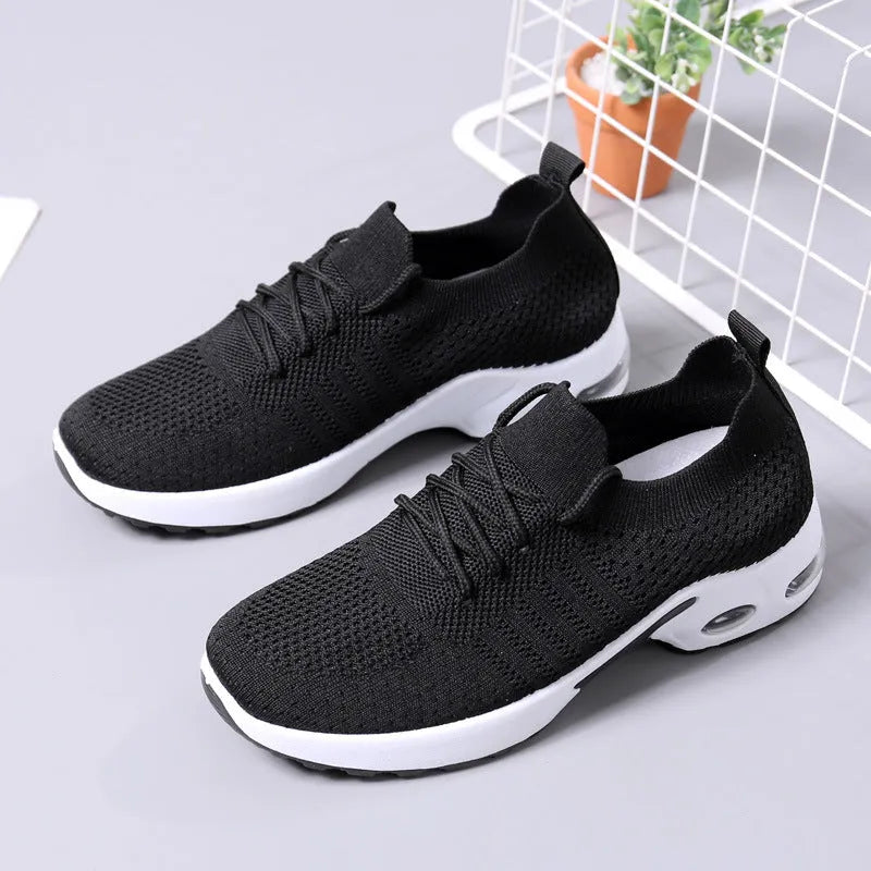 Women's black mesh casual sneakers with lace-up front and round toe on a grey background.