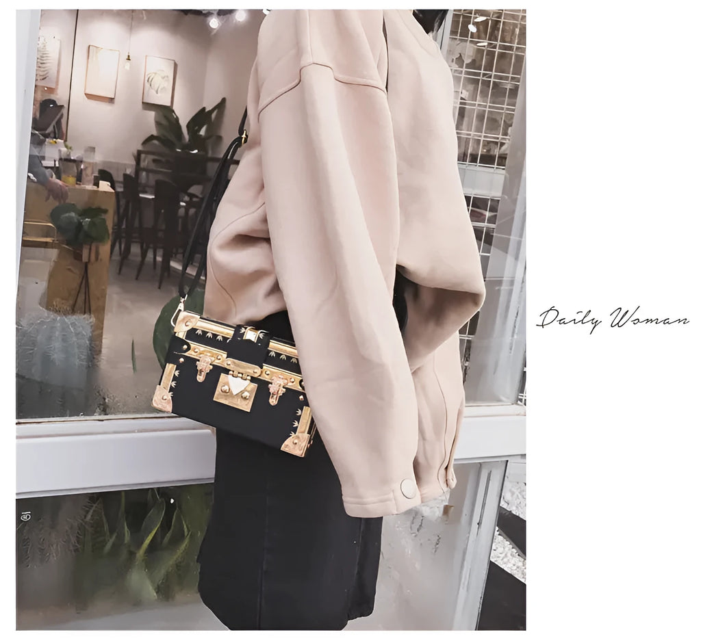 Hard structured black PU leather women's shoulder bag with decorative rivets and single adjustable strap