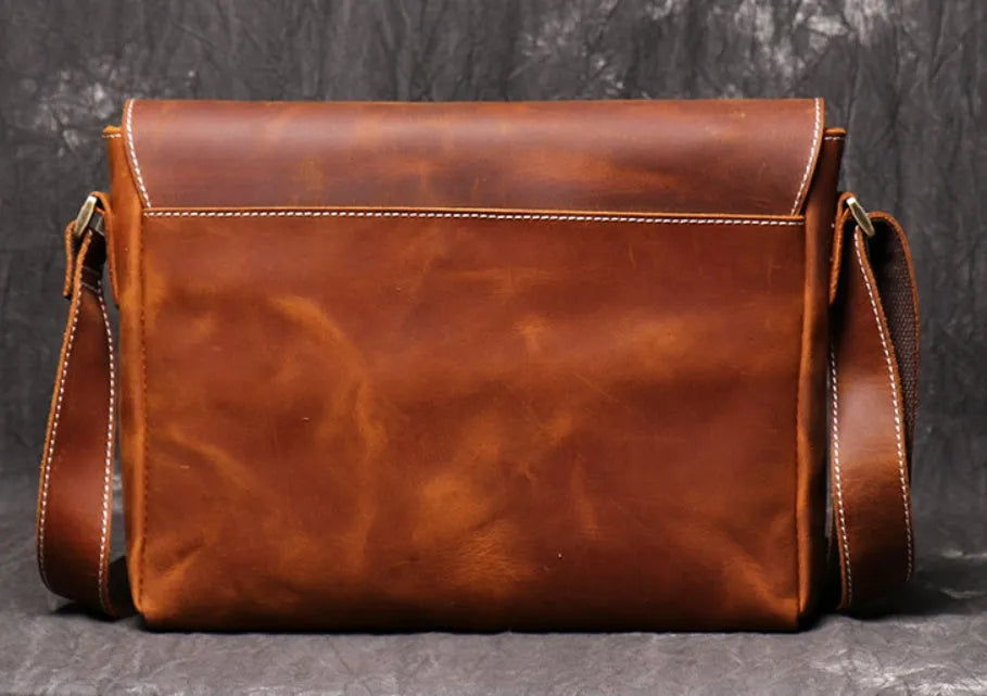 Vintage brown men's leather messenger bag showing interior compartments and adjustable shoulder strap