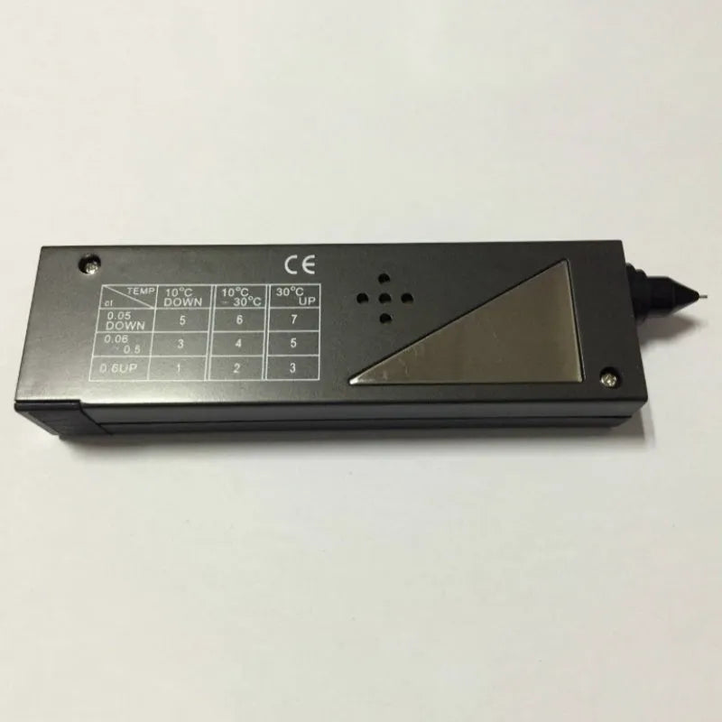 Black handheld Diamond Thermal Conductivity Tester with metal probe on a dark surface.