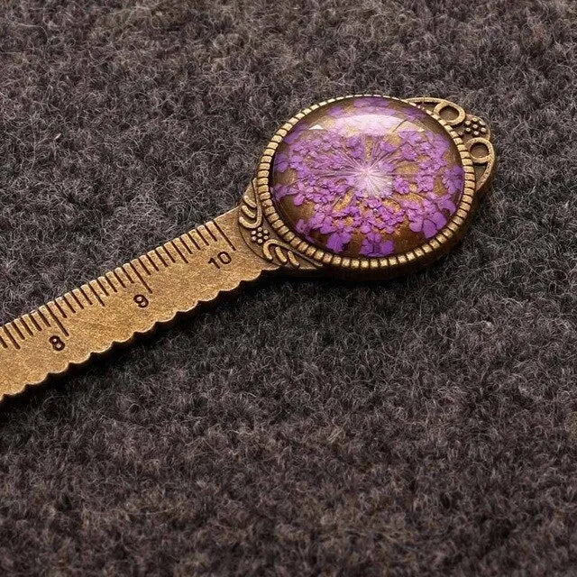 Handmade dried flower bookmark ruler with gypsophila, lace flowers, and clover, 12cm long on a book page.