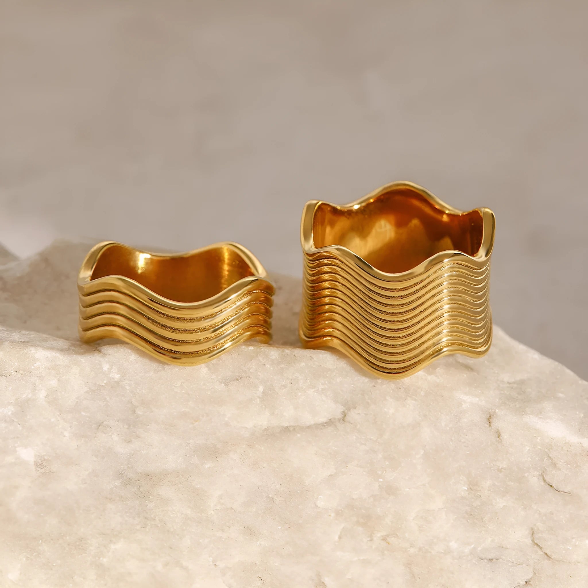Stainless steel wide wave ring with geometric design and electroplated finish.
