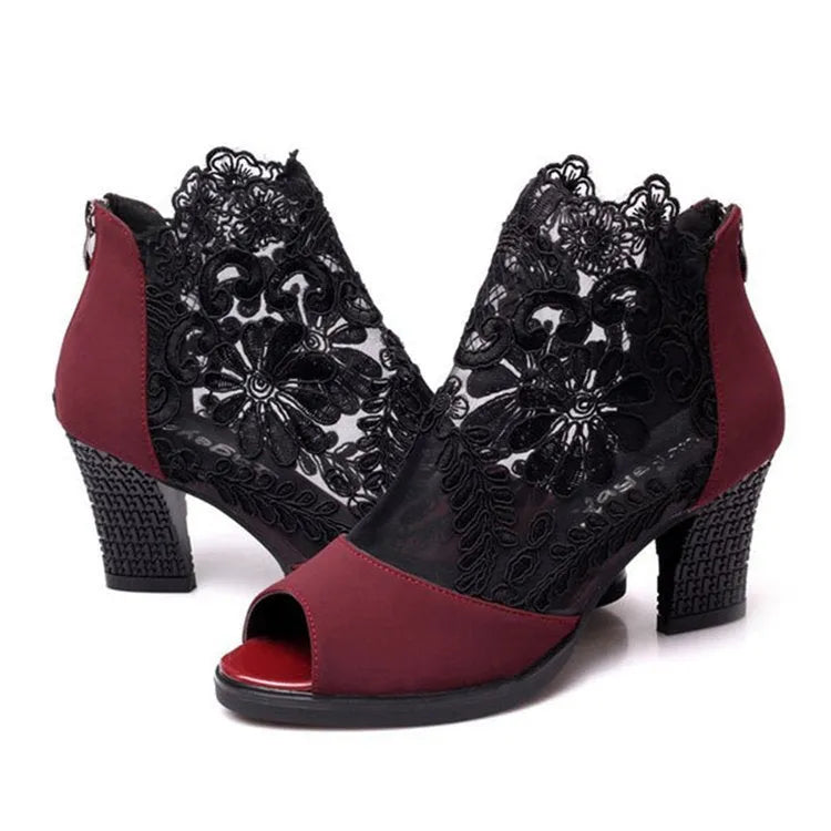 Black women's lace gladiator sandals with a zip closure, floral pattern, and a square high heel on a rubber outsole.
