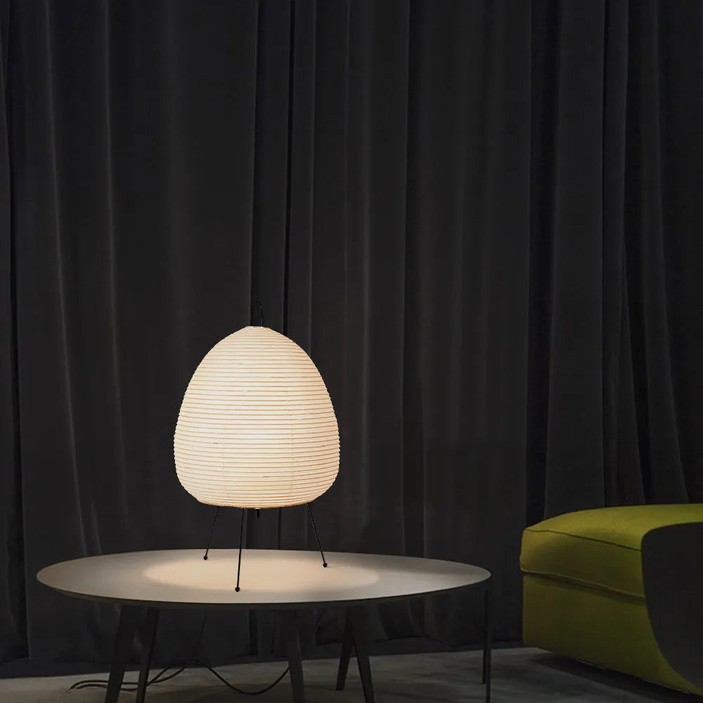 Nordic style table lamp with a handmade Japanese rice paper shade and aluminium base on a wooden table.
