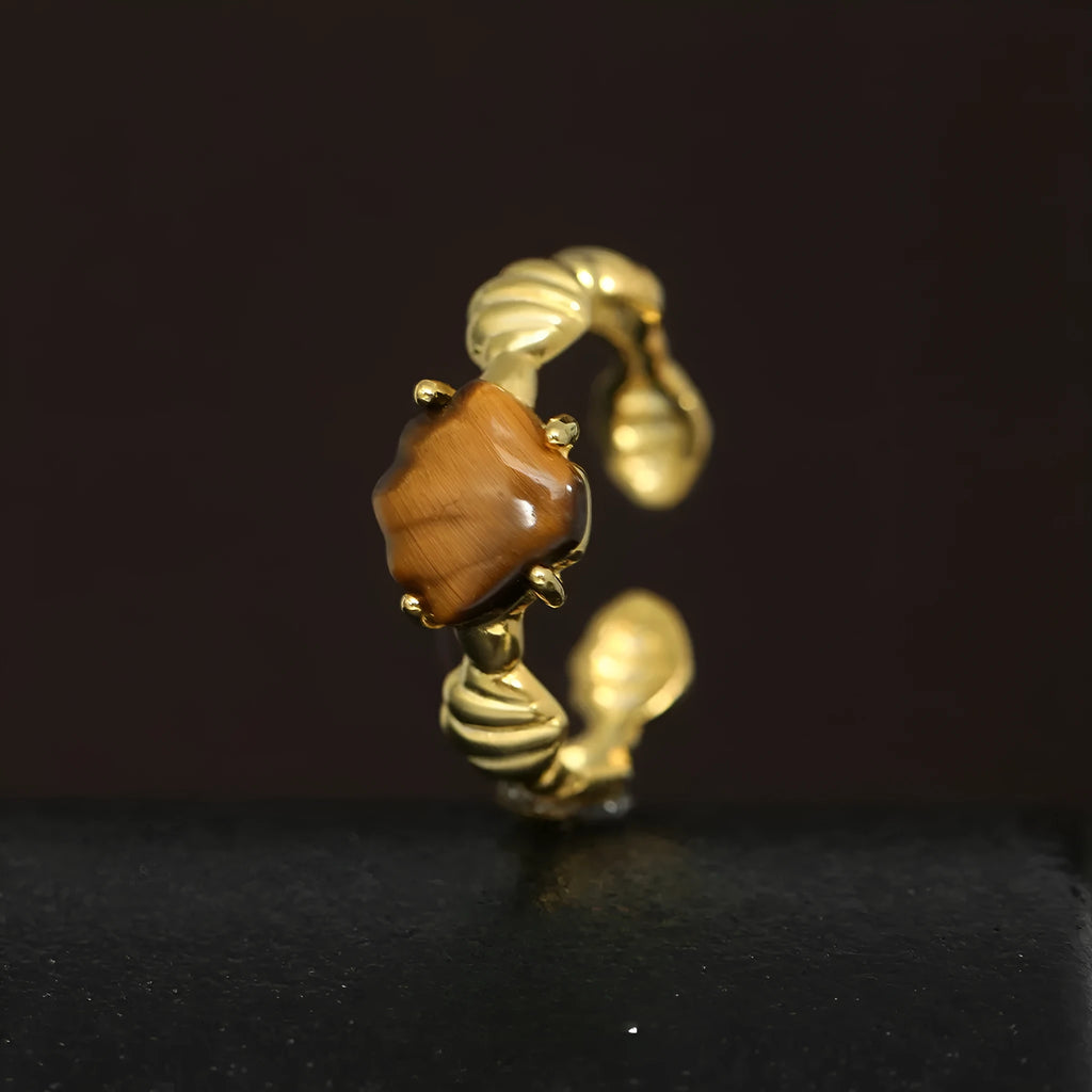 Women's adjustable silver ring with shell design and tiger eye accents in gold electroplated finish.