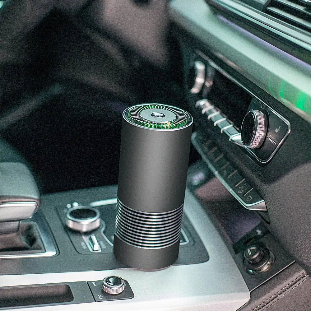 Compact aluminium alloy car air purifier in black, silver, or metallic grey for dashboard use.