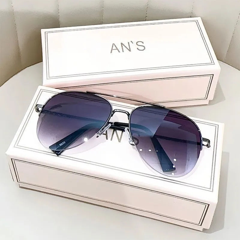 Aviator-style sunglasses with a metal frame and tinted resin lens, shown in a gold frame variant.
