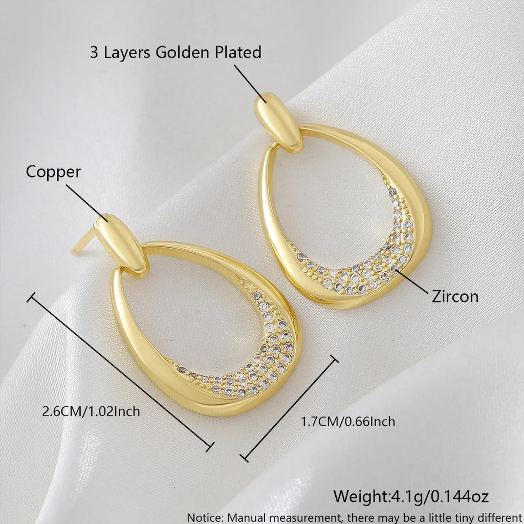 Yellow gold geometric women's drop earrings with a ring design and zircon detail on a white background.