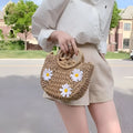 Women's daisy crossbody straw-weave bag in light brown woven material with floral decorative element, 25x20x8cm size