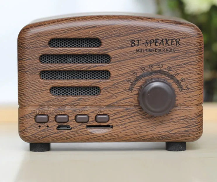 Vintage wood finish Bluetooth speaker in black colour on a wooden surface