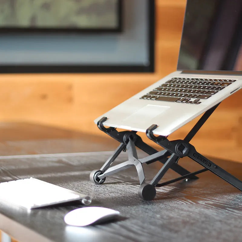 Black folding portable laptop stand made of reinforced nylon, shown in open and closed positions.