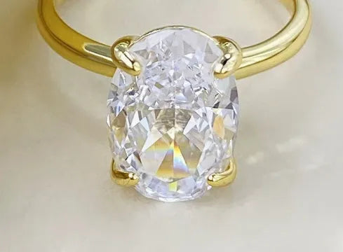 Women's oval silver ring with a four-claw setting holding a hand-cut gemstone.
