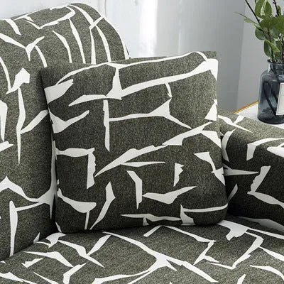 Stretchable geometric print sofa slipcover covering a three-seater sofa with matching pillow