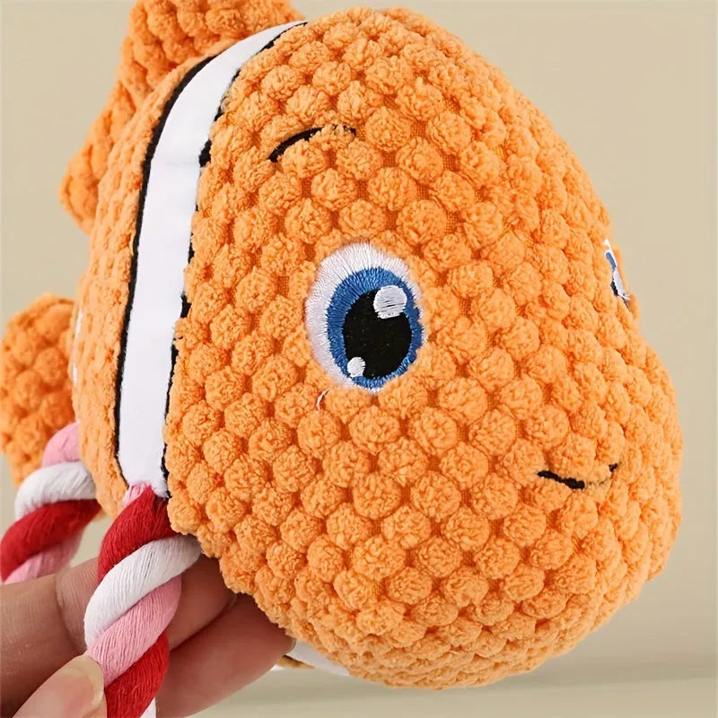 Grey, green, and orange turtle-shaped plush dog toy with knot details and squeaker.