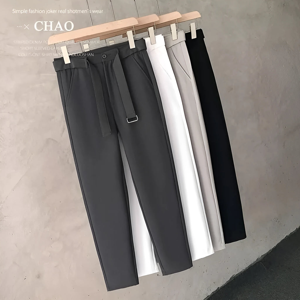 Boy wearing slim straight wool trousers in a neutral colour, showing tapered leg and straight hem.