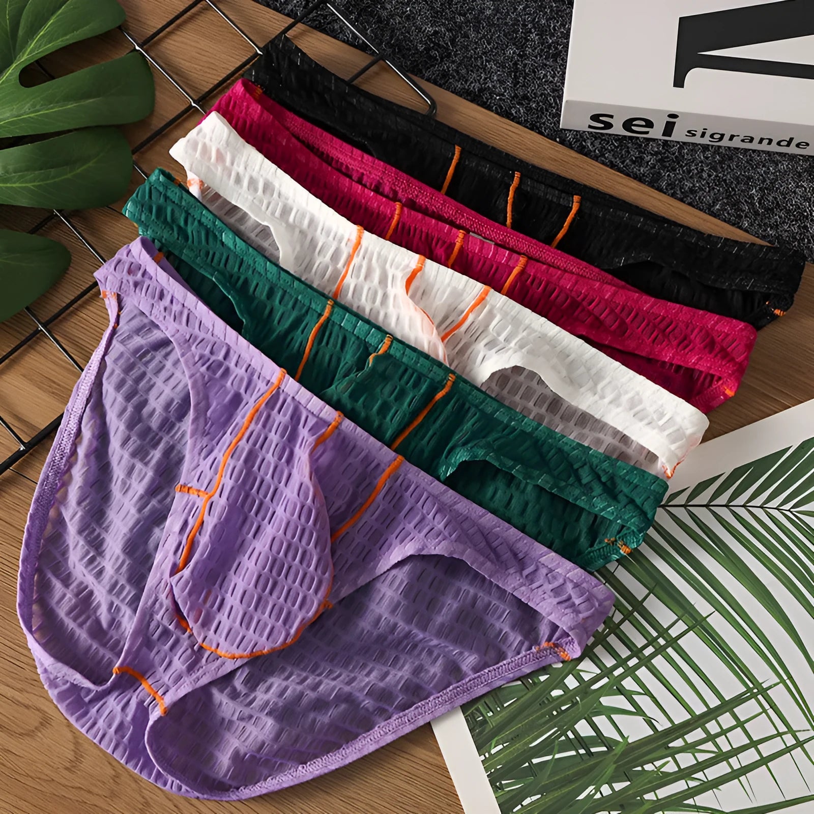 Men's solid colour ice silk lace low waist briefs for sports in white, black, green, rose red, and light purple.