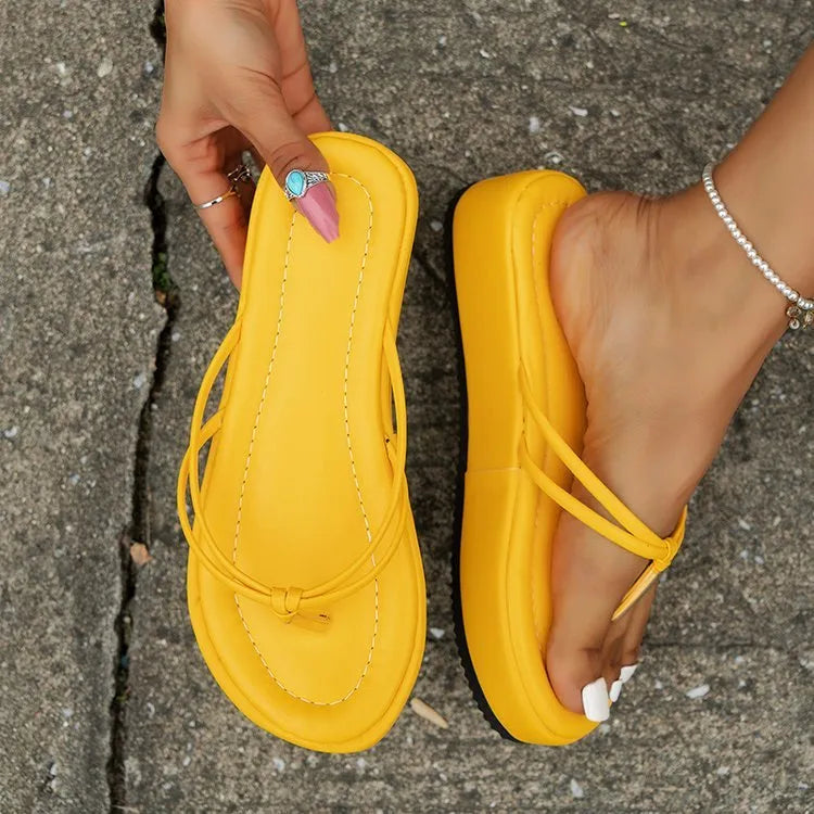 White thick-soled flip-flops with herringbone patterned PU upper and rubber sole.