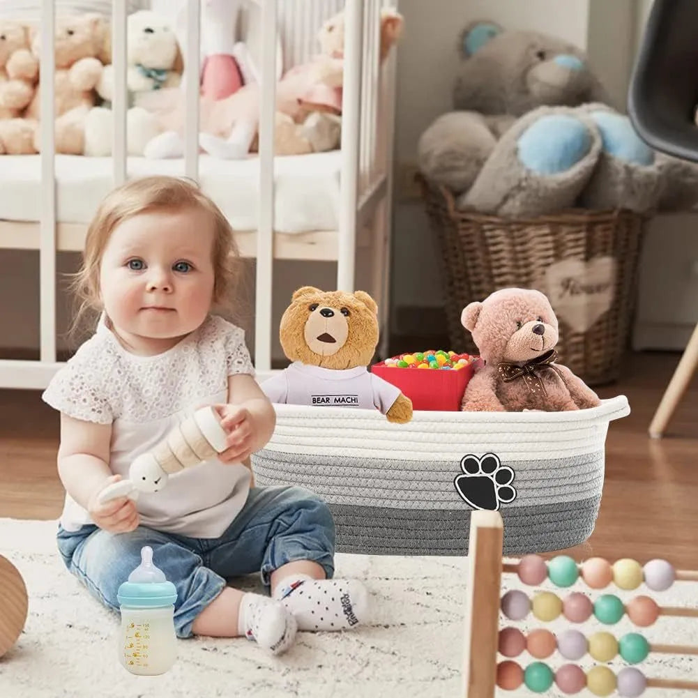 Small light beige handmade woven cotton rope storage basket with a handle on a wooden floor.