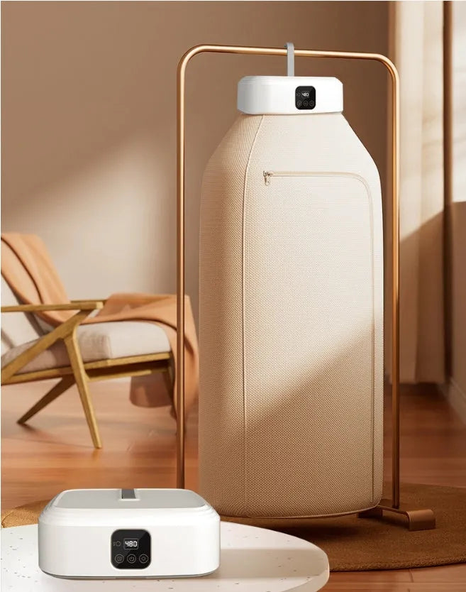 White cylindrical compact laundry drier with remote control on countertop