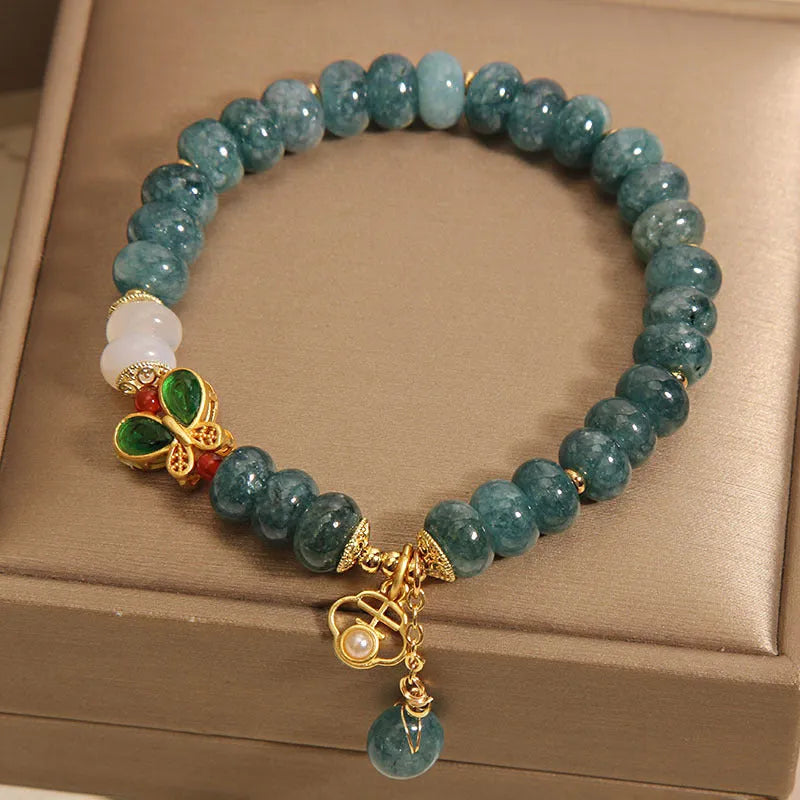 Women's blue water jade abacus bead bracelet with alloy charms, white agate, and rhinestone details