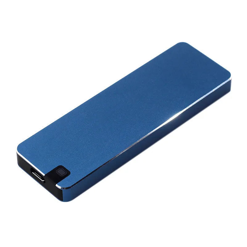 White portable external SSD with metal shell and USB cable next to a laptop.