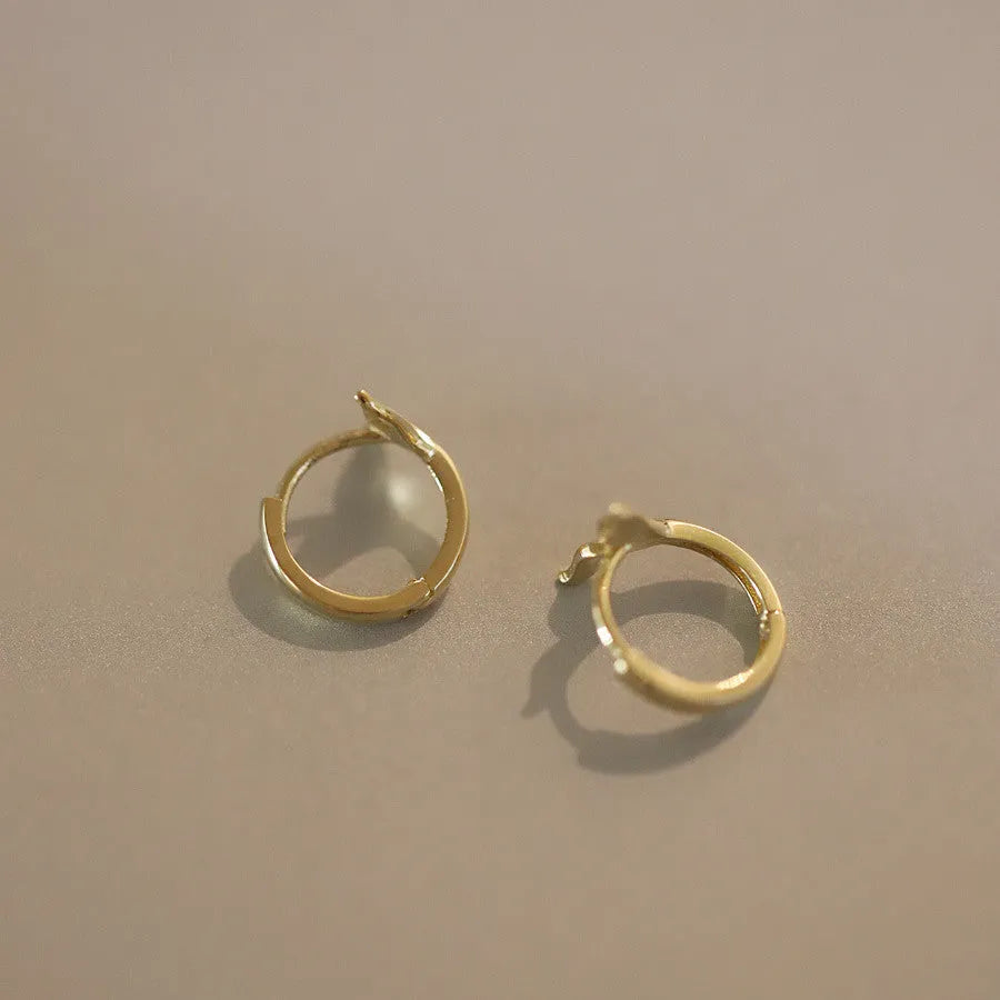 S925 sterling silver fishtail drop earrings in gold colour, showing smooth design and size.