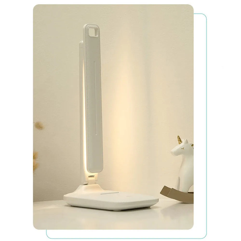 White plastic USB rechargeable bedside lamp with touch dimming control on a wooden surface.