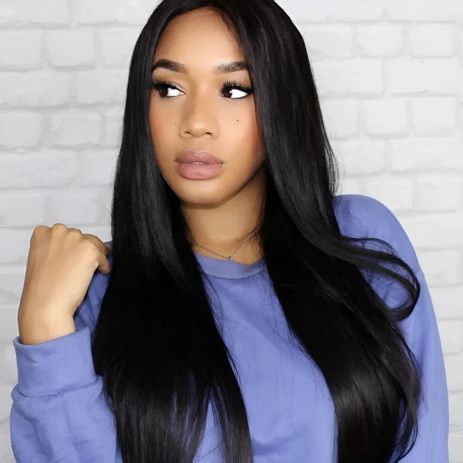Long straight black synthetic wig with centre-parted bangs on a model