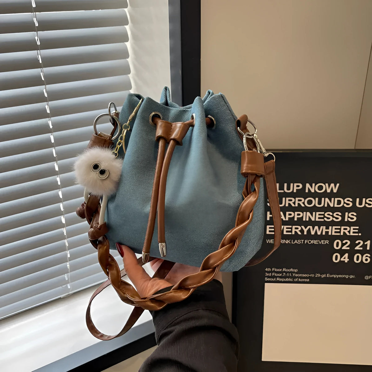 Blue one-shoulder cross body bucket bag with synthetic leather lining and sandwich pocket design