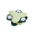 Green and yellow dog puzzle toy with rotatable treat dispenser and nine bone-shaped compartment covers
