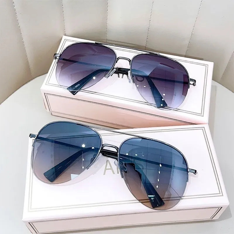 Aviator-style sunglasses with a metal frame and tinted resin lens, shown in a gold frame variant.