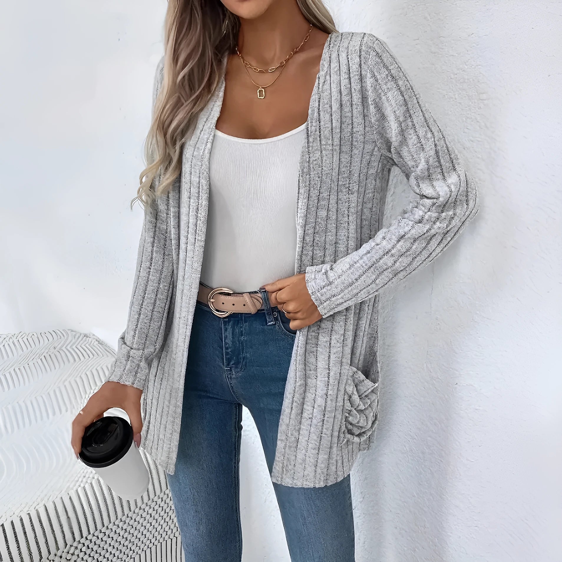 Long sleeve loose fit cardigan in grey with a pocket, shown on a hanger.