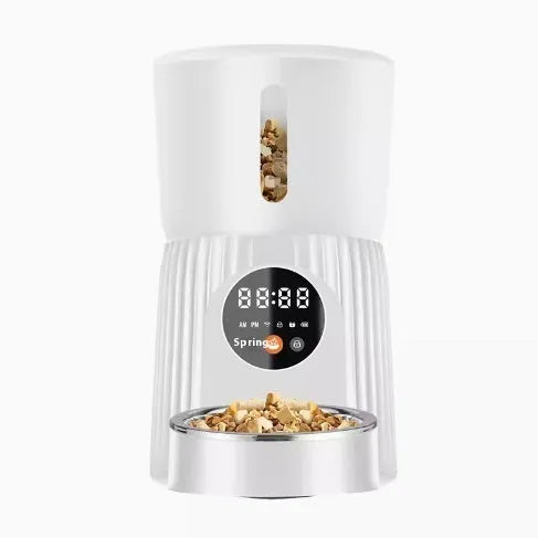 Black and white smart automatic pet feeder with USB cable and mobile app display showing feeding schedule.